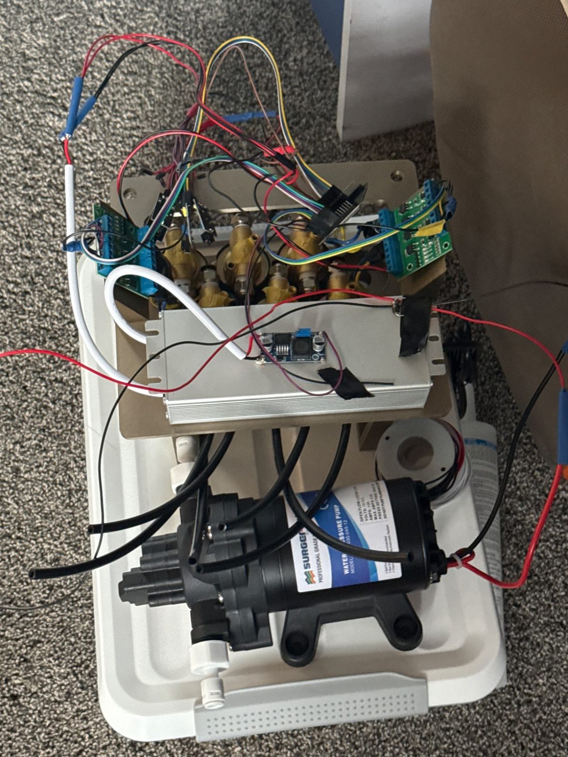 Prototype six-zone automated irrigation controller with ESP32 and Raspberry Pi wiring, power electronics, valves and water pump