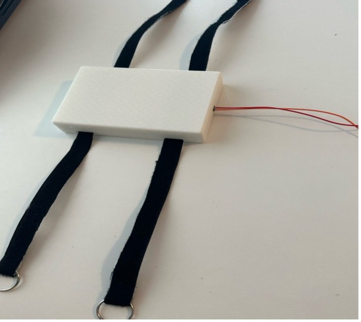 Wearable naloxone delivery concept prototype with light-coloured 3D-printed housing and attachment straps