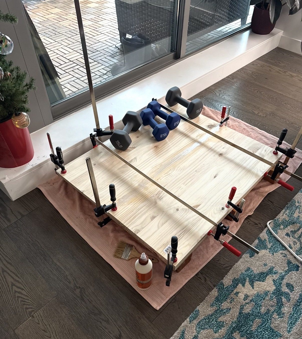 Wooden tabletop planks clamped for glue-up in home workshop